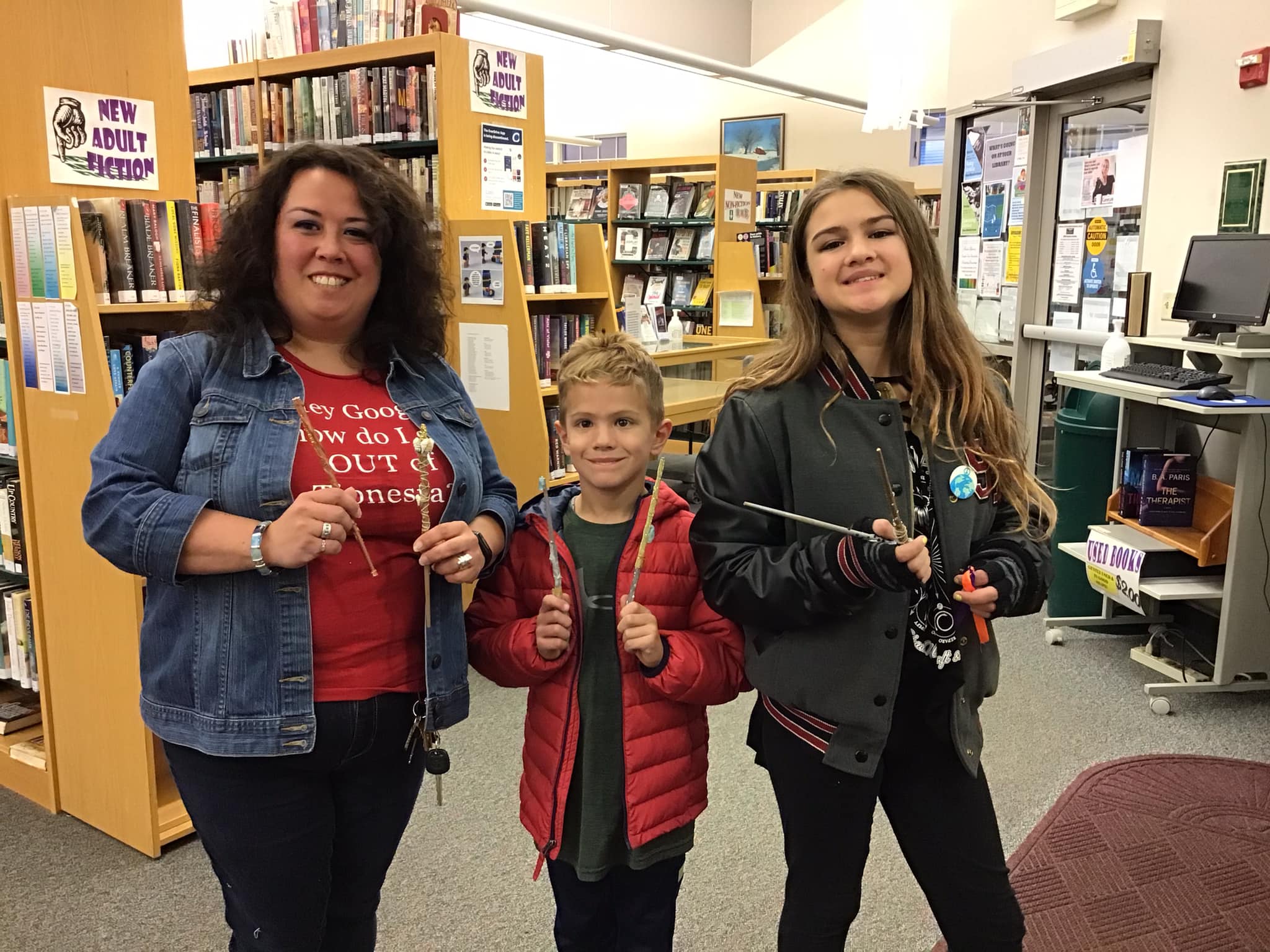 Three patrons are pictured holding the wands they created during the library's Wandmaking 101 craft session.